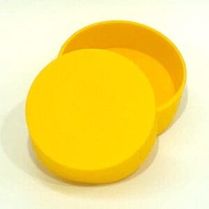 A yellow round container with lid on top of white surface.