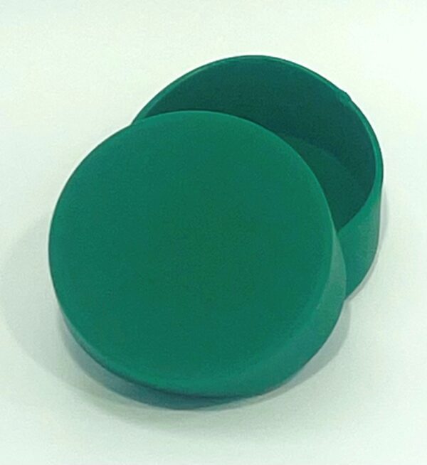 A green round box sitting on top of a table.