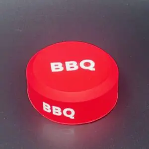 Red BBQ button on dark background.