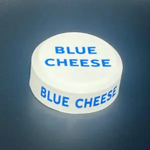 Blue cheese container lid on dark background.