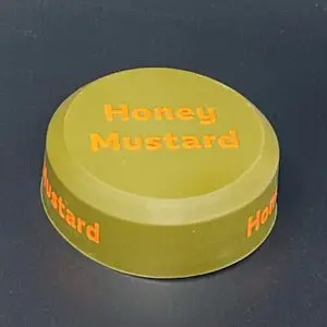 Honey mustard sauce container lid on table.