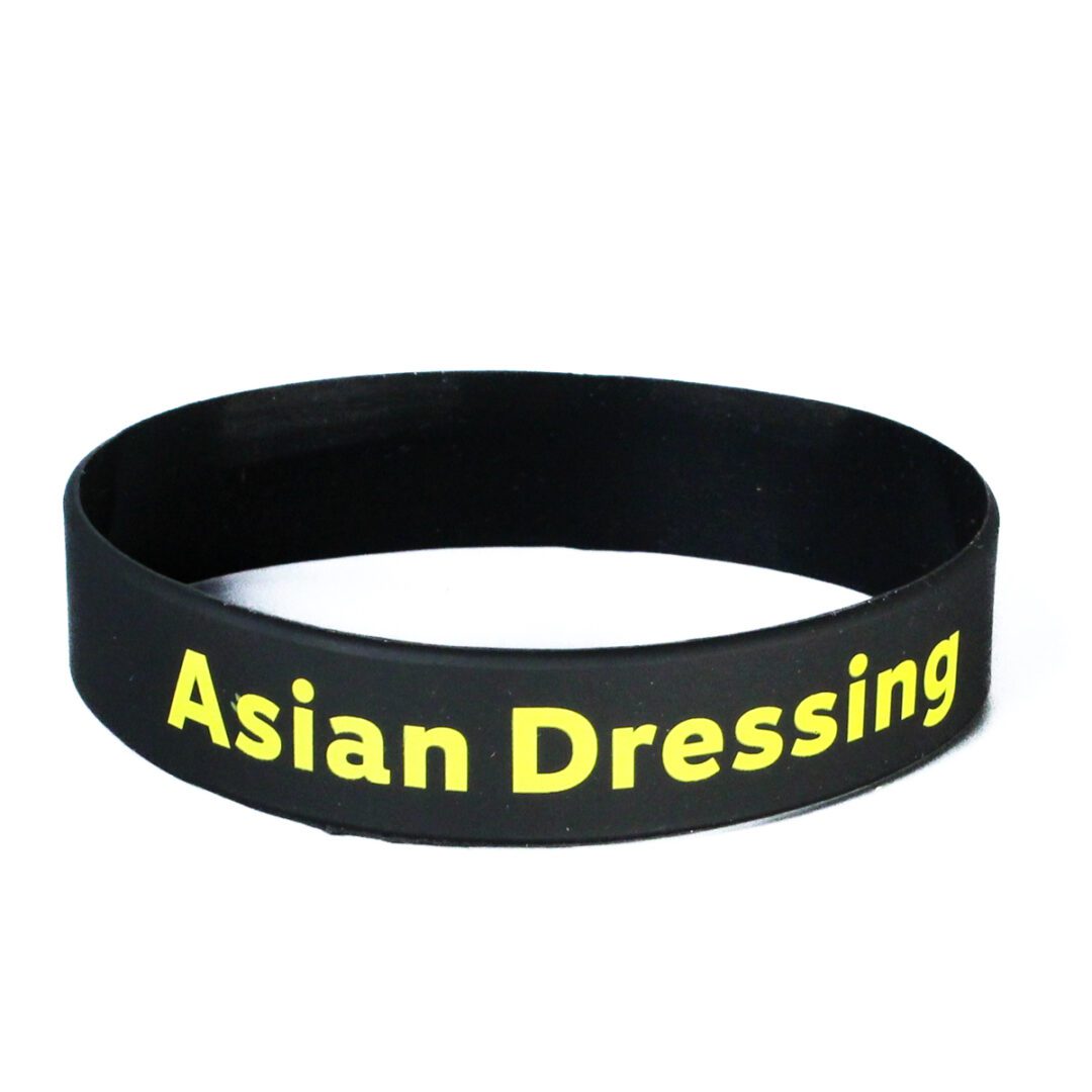 A black wristband with the words asian dressing written on it.