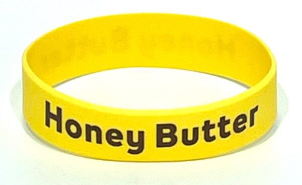 A yellow bracelet with the words honey butter on it.