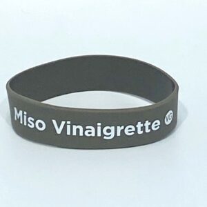Brown wristband with "Miso Vinaigrette" text.