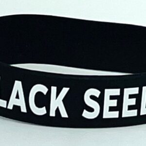 A black seed bracelet is shown on top of a table.