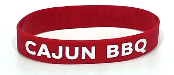 A red and white bracelet with the name " cajun blood ".