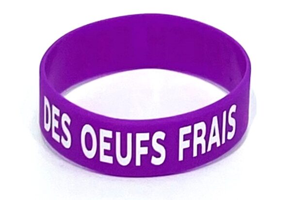 A purple bracelet with the words " des oeufs frais ".