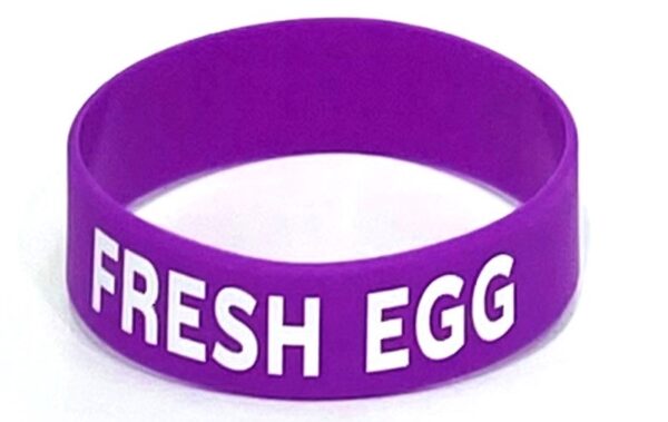 A purple rubber band with the words " fresh egg ".