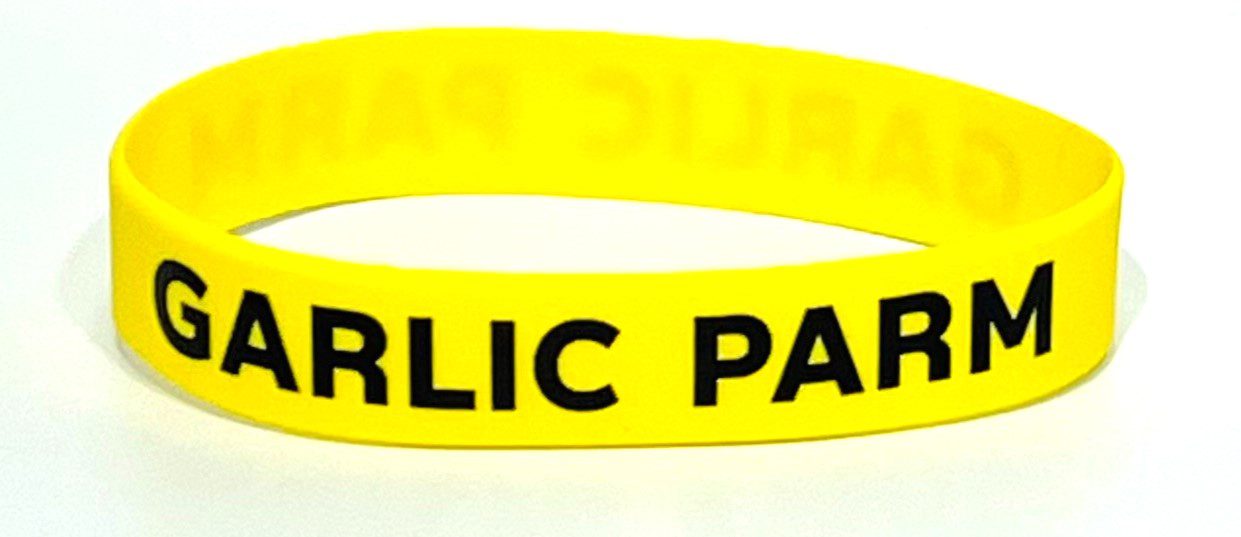 A yellow bracelet with the words garlic paste written on it.