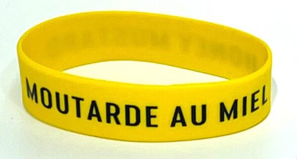 A yellow wristband with the words " tarde au mer ".