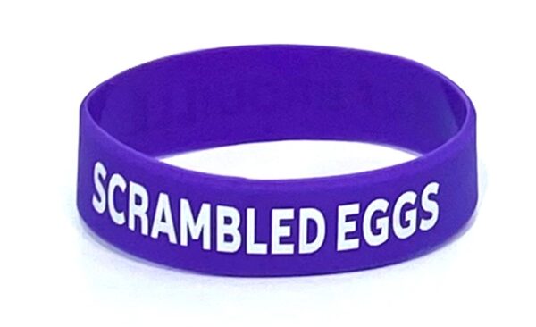 A purple bracelet with scrambled eggs written on it.