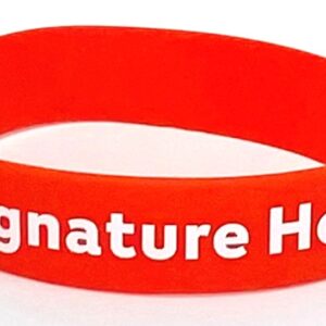 A red wristband with the words signature health written on it.