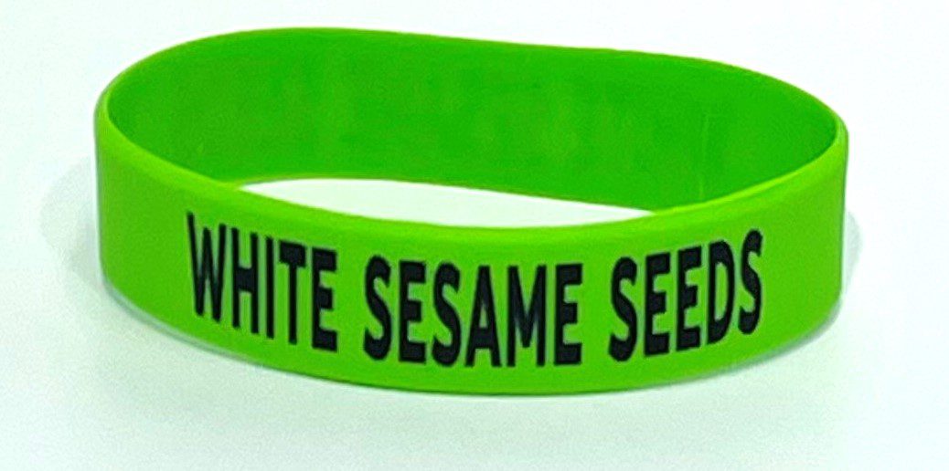 A green wristband with the words " white sesame seeds ".