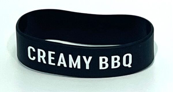 A black and white bracelet with the words creamy bbq written on it.