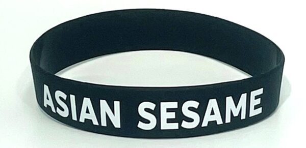 A black and white wristband with the words " i am sesan ".