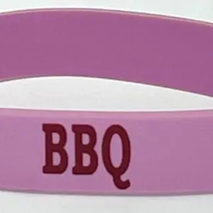 A pink wristband with the word bbq written on it.