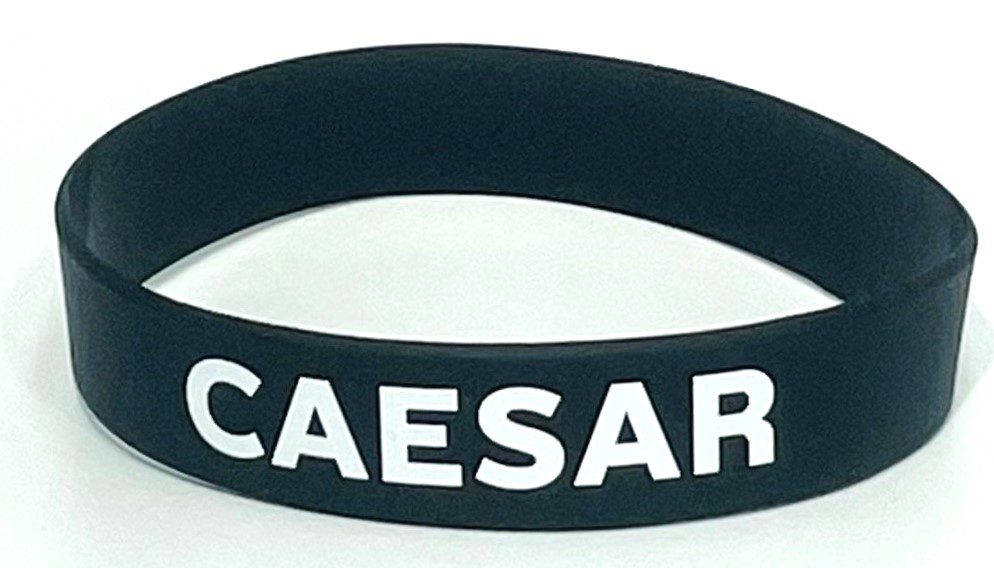 A black wristband with the word caesar written on it.