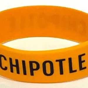 A chipotle wristband is shown on top of a table.