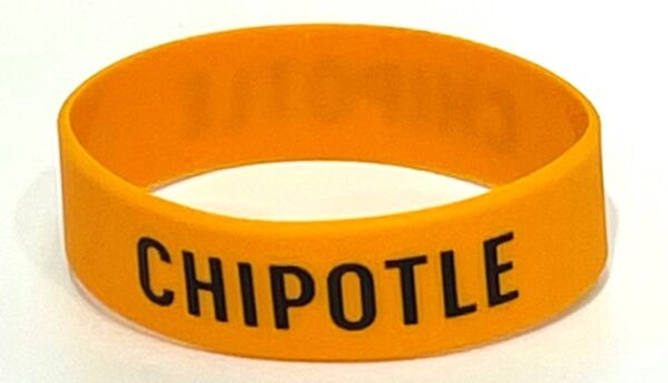 A chipotle wristband is shown on top of a table.