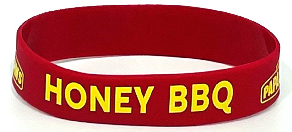 A red and yellow wristband with the words honey bbq written on it.