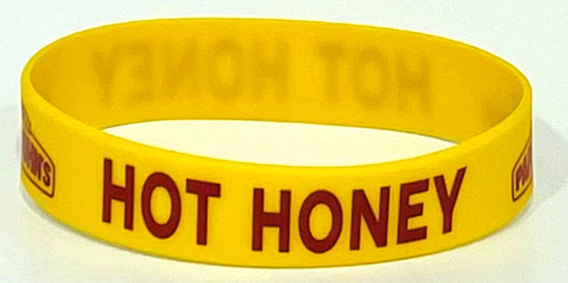 A yellow wristband with the words " hot honey ".