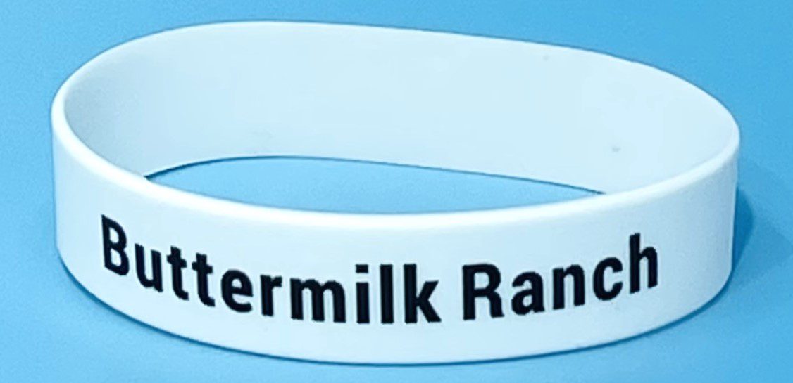 A white bracelet with the words " watermilk ranch ".