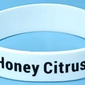 A white wristband with the words honey citrus on it.