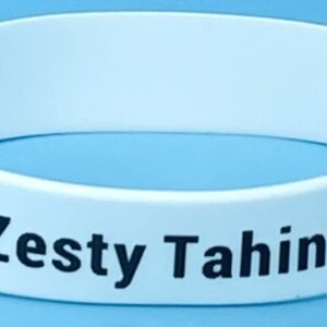 A white bracelet with the words zesty tahini written on it.