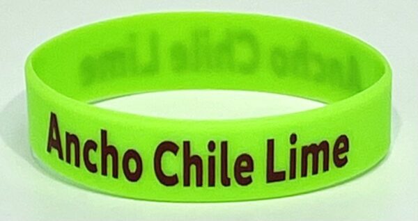 A green bracelet with the words " chico chile limes ".