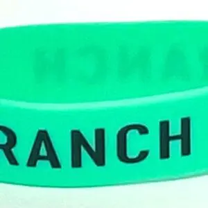 A green bracelet with the word ranch written on it.