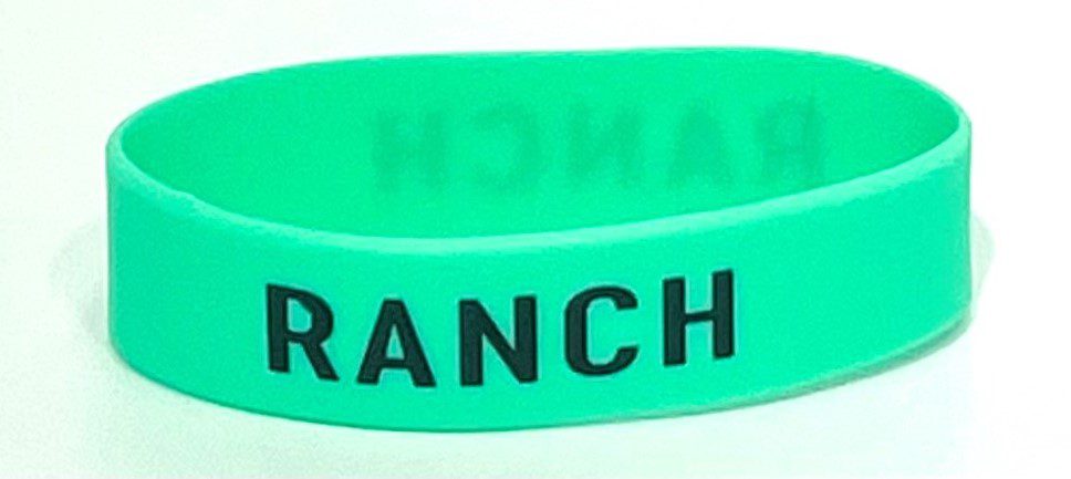 A green bracelet with the word ranch written on it.