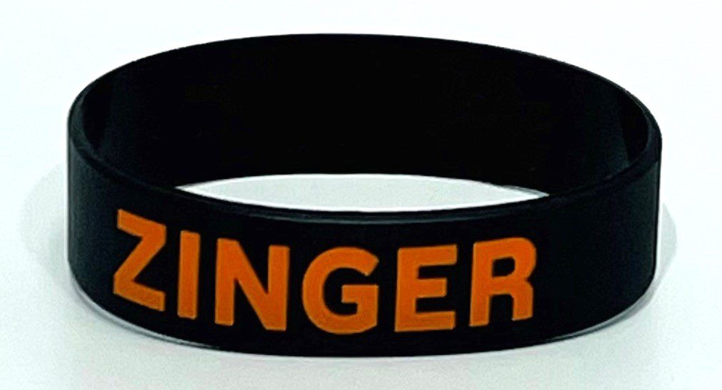 A black and orange wristband with the word " ginger ".