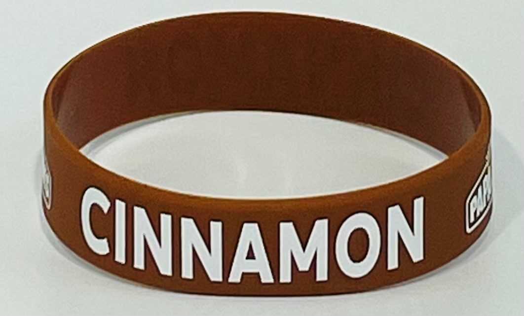 A brown and white cinnamon bracelet with the word cinnamon on it.