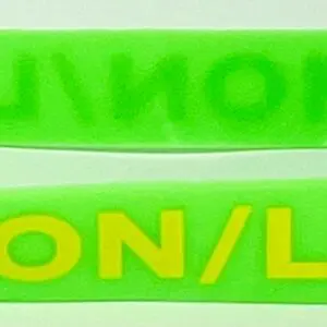 A close up of two green bracelets with yellow lettering