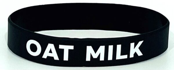 A black and white wristband with the words " eat milk ".