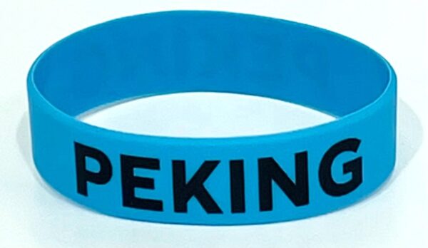 A blue bracelet with the word " peking " written on it.