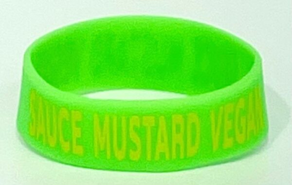 A neon green bracelet with the words " produce mustard vegetables ".