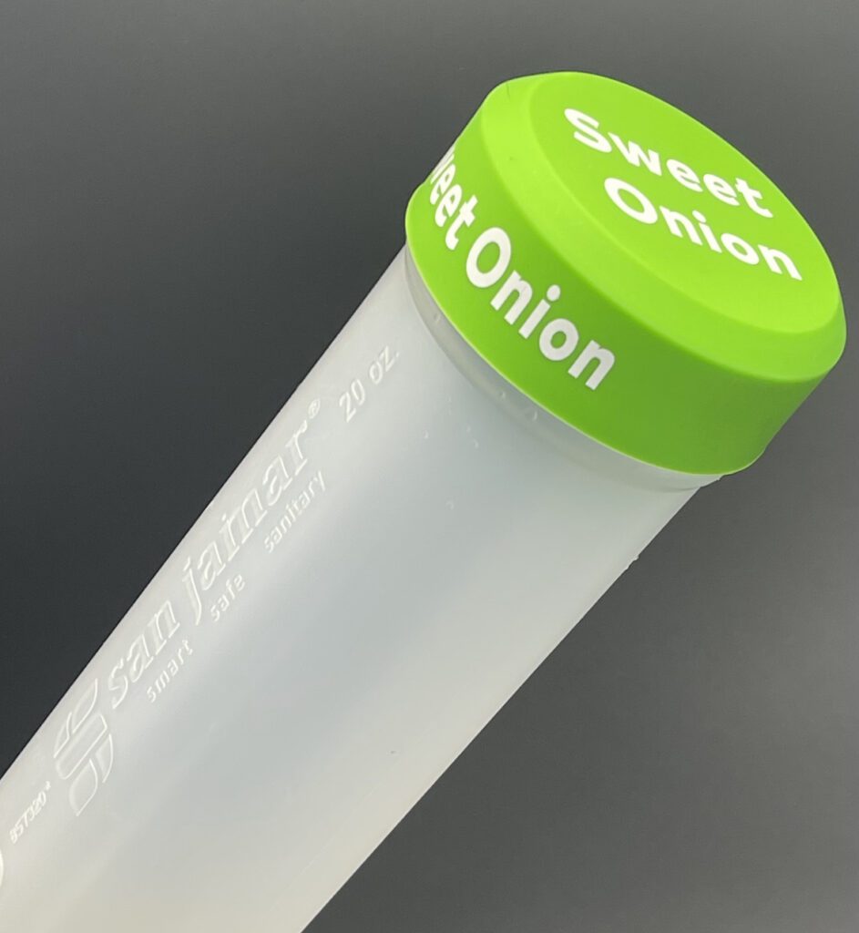 A close up of the top of a tube with a green lid.