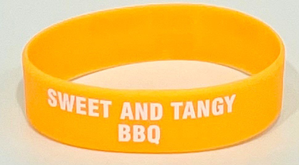 A yellow bracelet with the words " sweet and tangy bbq ".