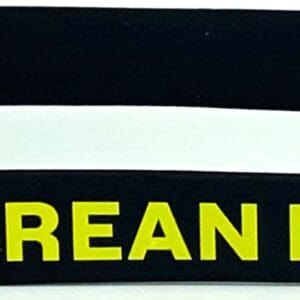 A black and yellow wristband with the words korean pride on it.