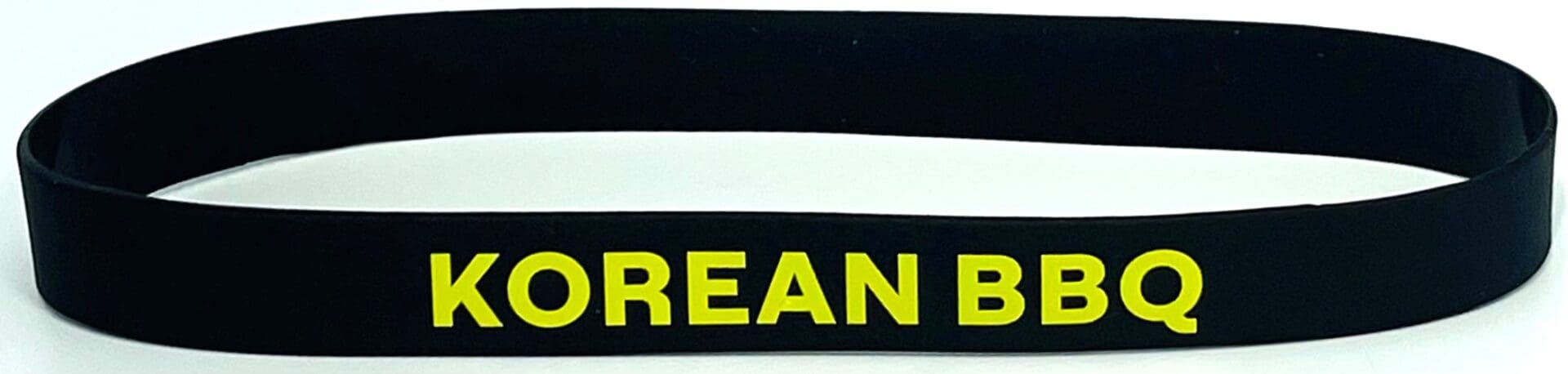 A black and yellow wristband with the words korean pride on it.