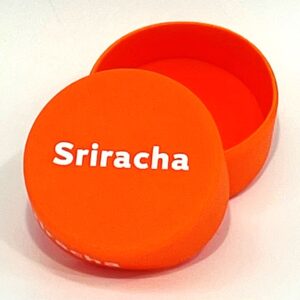 A round orange box with the name sriracha on it.