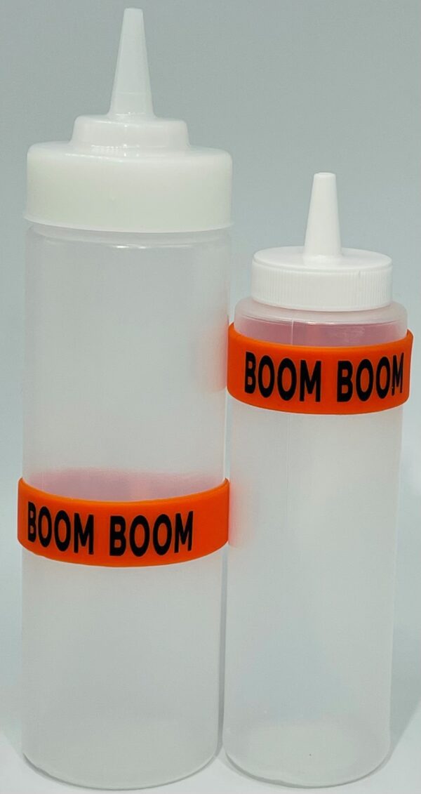 A bottle of boom boom sauce next to a container.