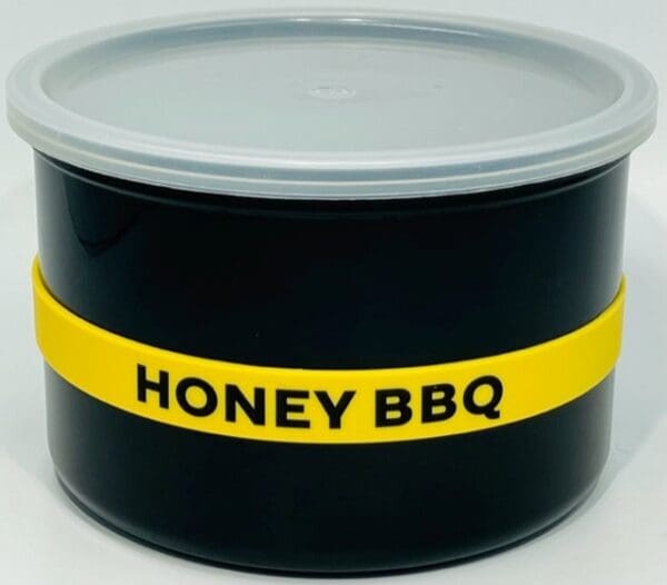 A black container with yellow and white tape around it.