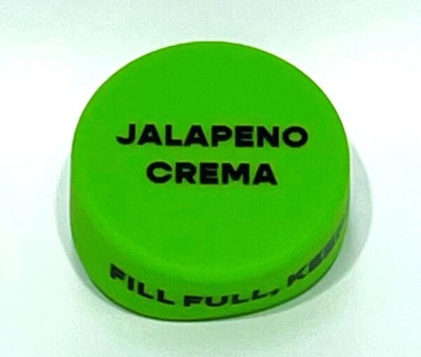 A green container with the words " jalapeno crema " written on it.