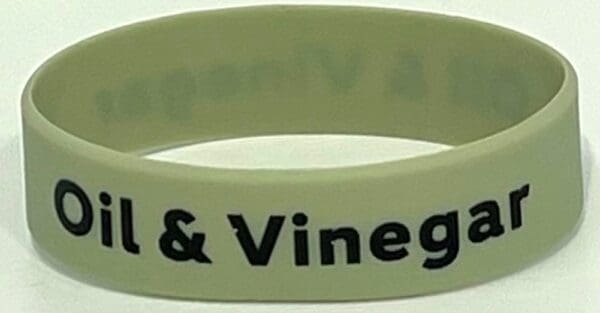 A glow in the dark wristband with words " wine & vinegar."