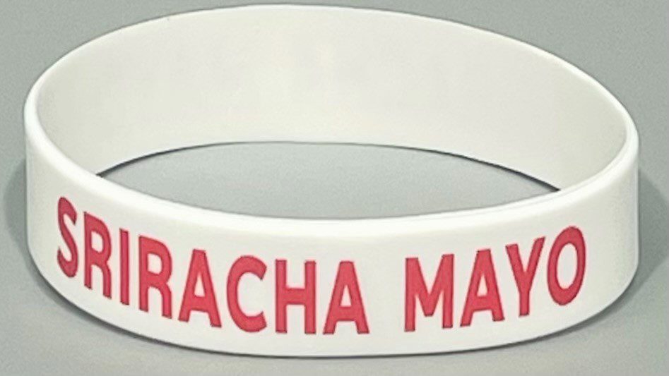 A white bracelet with the name of " racha may ".