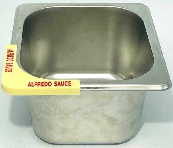 A metal container with alfredo sauce on it.