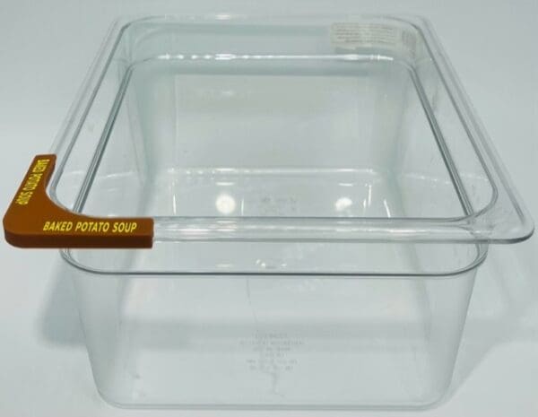 A clear plastic container with a brown handle.