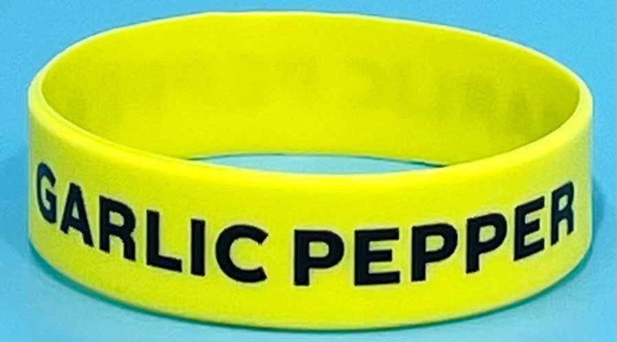 A yellow bracelet with the words public peperoni written on it.